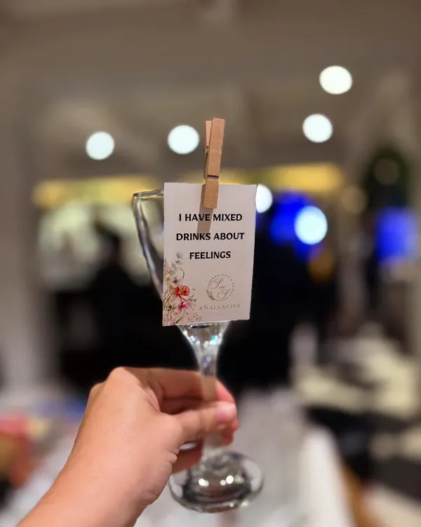 We love adding a bit of wit to our service. This custom glass tag, clipped on with a rustic clothespin, reads "I have mixed drinks about feelings," adding a playful touch that gets guests smiling.