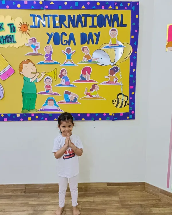 A little yogi in a 'namaste' pose on International Yoga Day. We introduce children to yoga early to promote flexibility, balance, and mindfulness.