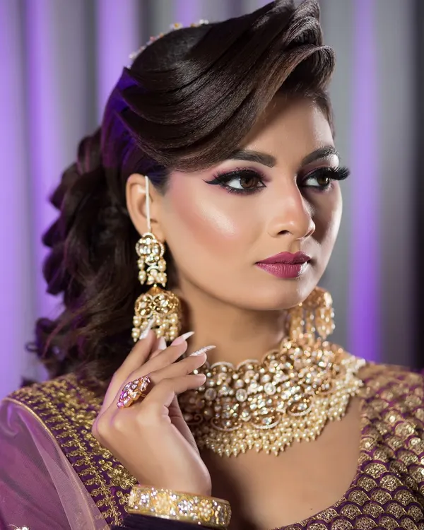 A perfect example of a glamorous reception look. The side-swept voluminous hair and dramatic makeup are ideal for an evening party.
