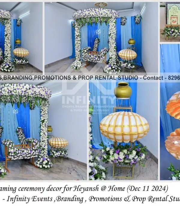 A beautiful naming ceremony decor at home, blending traditional and modern elements. The setup features a floral-decorated swing and a unique seashell prop for the name reveal, against a blue and white draped backdrop.