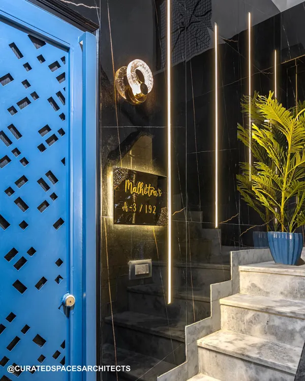The entrance to your home should be bold and beautiful. For this project, I used a vibrant blue door with a custom laser-cut pattern, black marble walls, and dramatic linear lighting to create a stunning first impression.