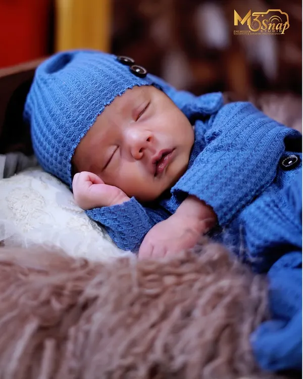 A close-up of a peacefully sleeping newborn in a cozy blue knit outfit. I focus on capturing the tiny details, like their soft cheeks and gentle breaths, that you'll want to remember forever.