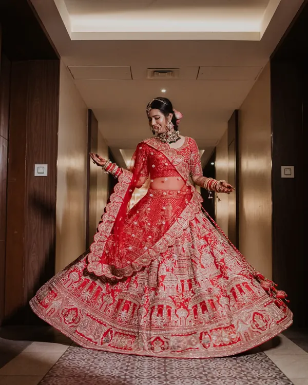 A breathtaking shot of the bride twirling in her magnificent red lehenga. We love creating these moments that showcase the beauty and grandeur of the bridal outfit.