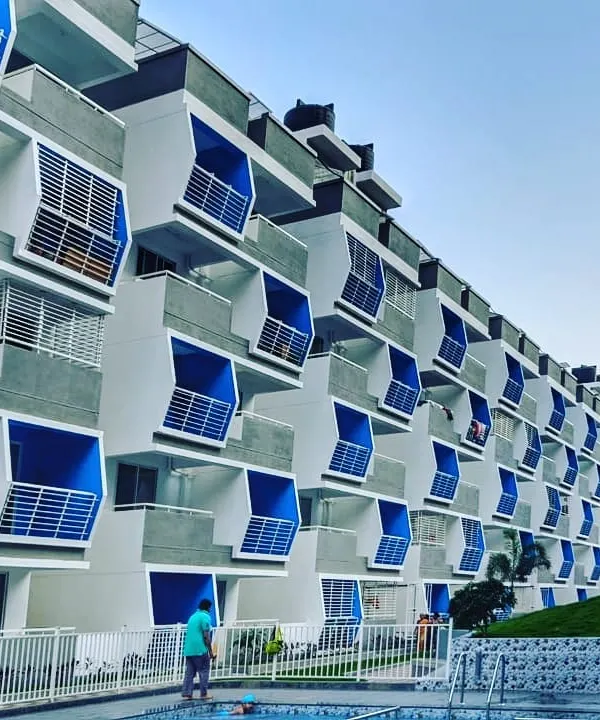 The Mars Mount luxury apartment complex, featuring over 120 homes. The facade is defined by a rhythmic pattern of angled blue balconies, creating a visually striking exterior.
