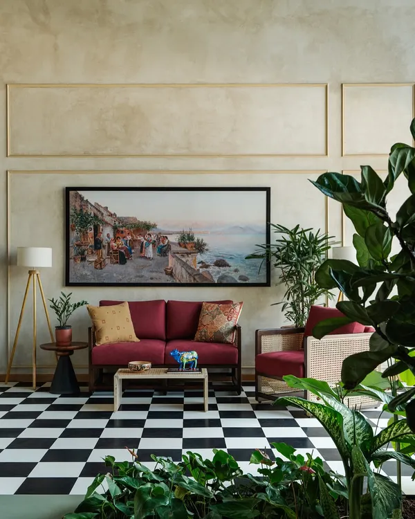 For the Primus Senior Living sales lounge, we designed this comfortable seating area featuring a custom red sofa and a cane armchair. The classic black and white checkered floor and large artwork create an eclectic, welcoming atmosphere.