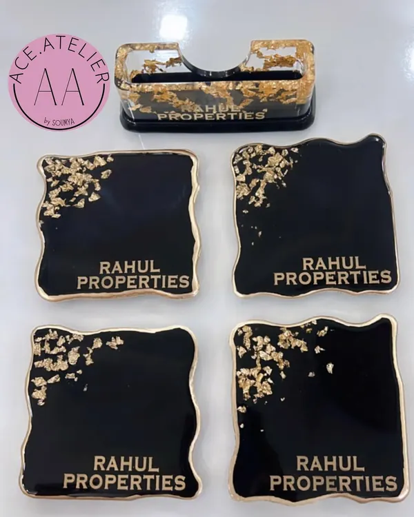 A sophisticated corporate gift set, including a card holder and four matching coasters, all personalized for 'Rahul Properties' in a classic black and gold design.