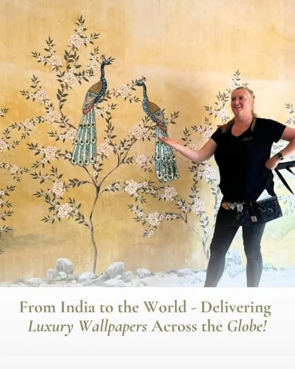 A client proudly showcasing her new wall featuring a stunning Chinoiserie-style mural with peacocks and blossoms. I can deliver these luxury, heritage-inspired designs to clients anywhere in the world.