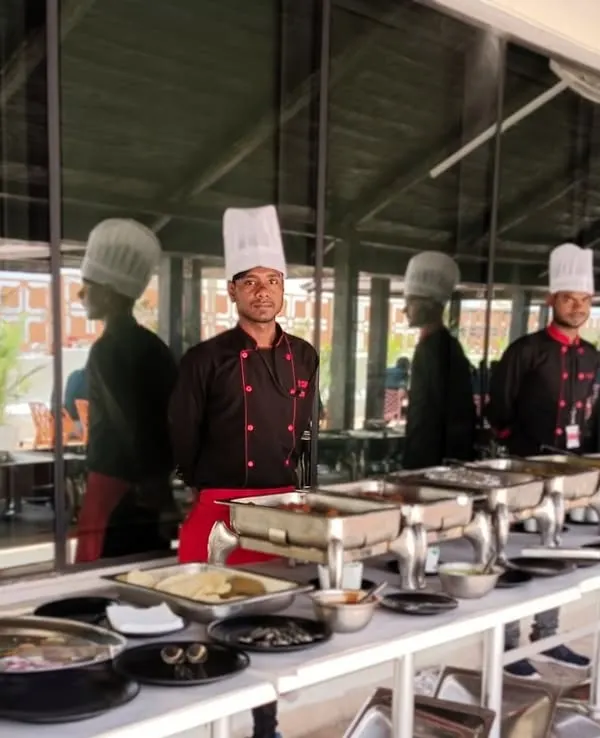 A full buffet line ready for a corporate lunch at IQVIA. Our team stands ready to serve, ensuring every dish from salads to main courses is perfectly presented.