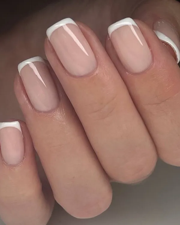 The quintessential classic French manicure. This look on short, square-shaped nails features a natural pink base and crisp white tips for a timelessly clean and elegant style.