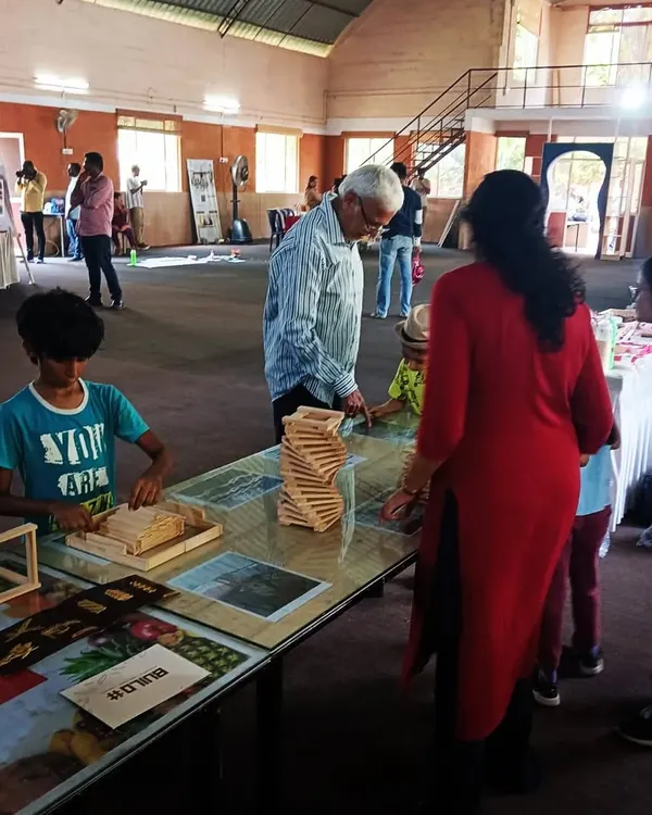 We love seeing multiple generations building together. Here, a grandfather offers his wisdom while a child and parent work on their structure. Our workshops are truly a family affair, creating a space for shared learning and bonding across all ages.