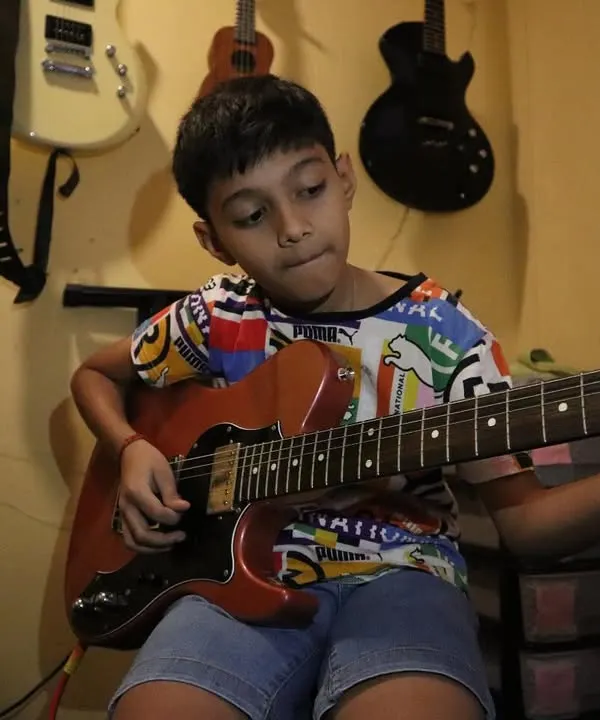 The focus in his eyes says it all. Here, we help students channel their passion into every note, learning the art of electric guitar with dedication.