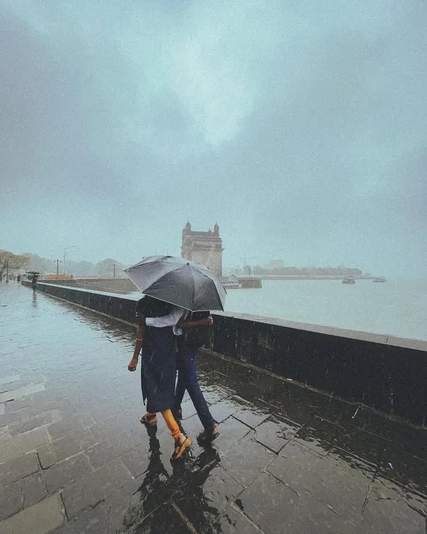 A quiet moment for a couple sharing an umbrella, with the iconic Gateway of India standing softly in the monsoon mist. This is the kind of love story I live to capture, simple and profound.