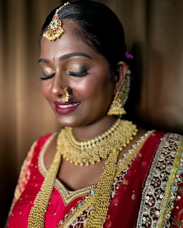 An unedited iPhone click showing a stunning South Indian bridal look on dusky skin. The gold eyeshadow and red lips pop beautifully.