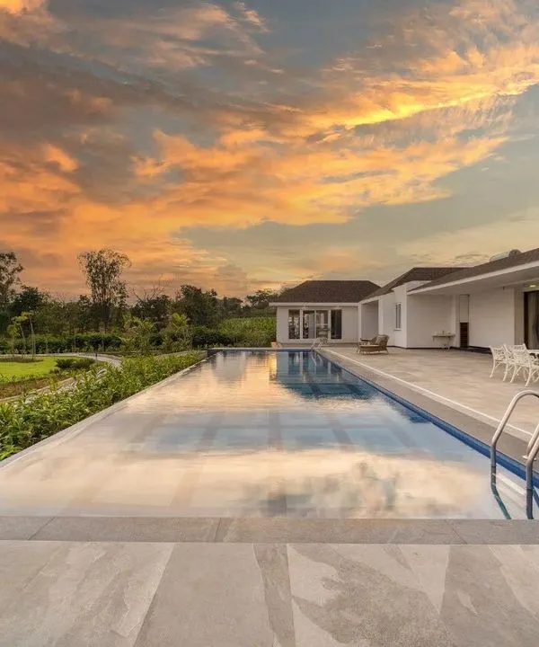 For this farmhouse by the backwaters, the infinity pool and patio are positioned to capture breathtaking views. The landscape design ensures an uninterrupted reflection of the sky, making the pool a tranquil mirror of the natural surroundings.