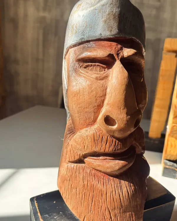 A story told in grain and groove. This hand-carved wooden bust, with its weathered expression and detailed texture, is filled with quiet strength.