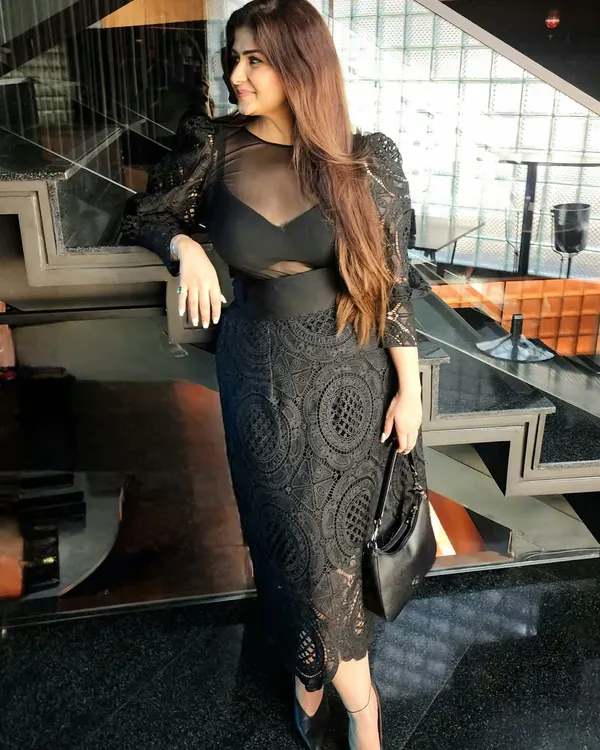 A classic black dress is more than just fashion; it's a statement of presence and power. This look, featuring a lace dress with sheer details, shows how choosing black isn't about blending in, but about defining your space.