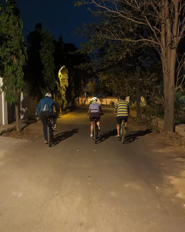 Three of us cycling down a quiet, tree-lined road in old Whitefield. This is the essence of our rides: peaceful, conversational, and surrounded by the calm of the night.