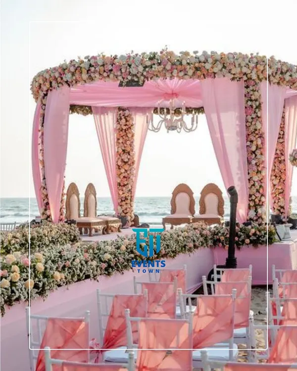 A stunning pastel pink mandap set against the serene backdrop of the sea. This destination wedding setup combines soft, romantic florals with elegant drapery, creating a truly unforgettable ceremony space.