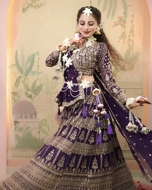 A full-length shot of our Radha-inspired look for Janmashtami, featuring a beautiful purple lehenga and delicate floral jewelry.