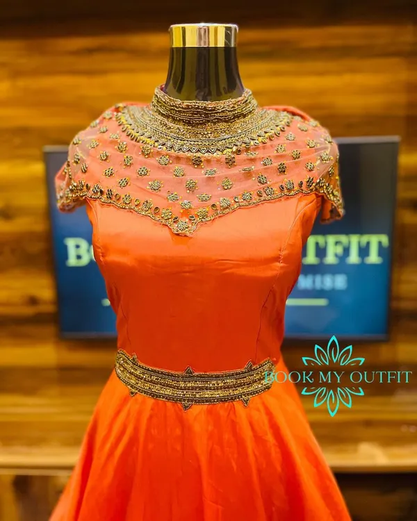 This custom-made orange gown is designed for parties and special events. It features an intricately hand-beaded illusion neckline and a matching belt, creating a sophisticated silhouette that is tailored to your measurements.