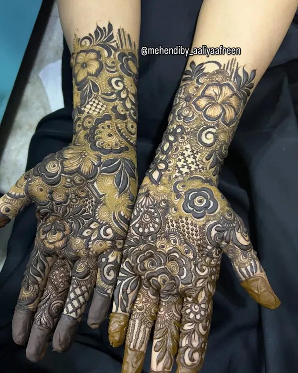 A closer look at the kind of intricate floral and geometric patterns you can learn to create. This design combines bold hibiscus flowers with delicate checkered fills and leafy vines, covering the hands beautifully. This is the level of detail we work towards in my advanced course.