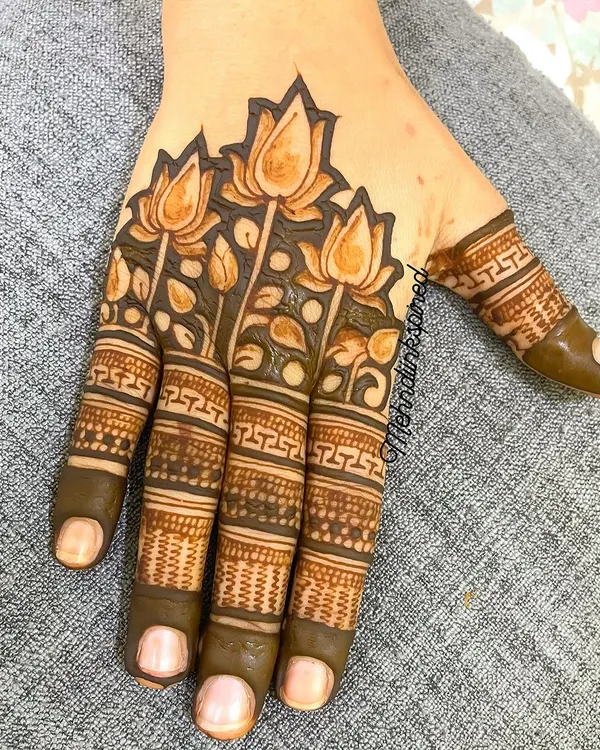 For the lover of minimal henna, this design features a beautiful band of lotus flowers across the back of the hand. The fingers are detailed with geometric bands, leaving the palm open.