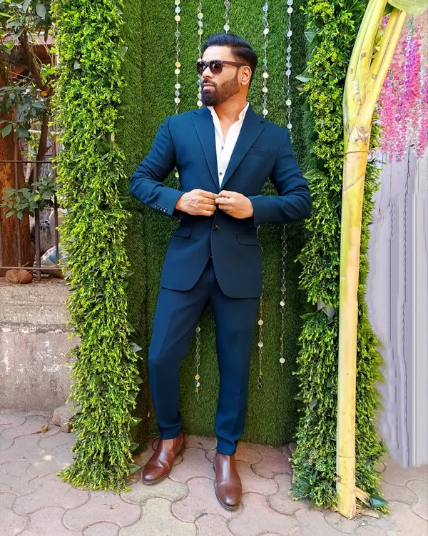 Ability is essential, but attitude is crucial. Rocking a sharp blue suit for a formal event.