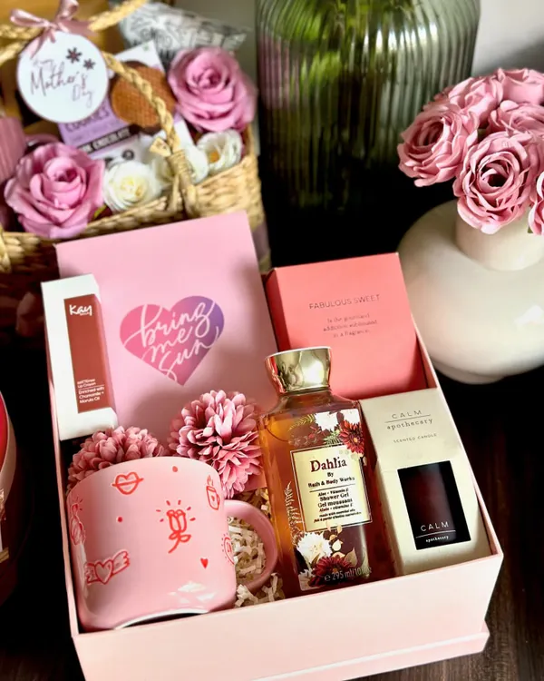 A luxury Mother's Day hamper to truly spoil her. This beautiful box includes a full-size Zara perfume, a Bath & Body Works shower gel, a Kay Beauty lip color, and a Marks & Spencer coffee mug and scented candle.