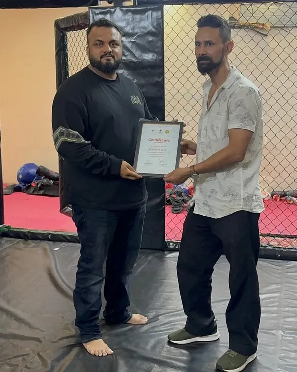 Here I am presenting a certificate to our wrestling coach, Ravi sir. We believe in recognizing the experts who help improve our team's overall game.
