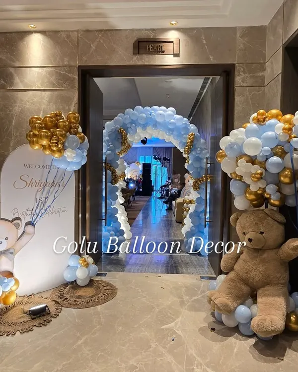 A grand entrance for a teddy bear themed first birthday, featuring a massive balloon arch and adorable bear props.