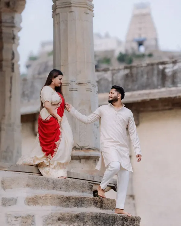A beautiful shot of an expecting couple at the historic Melukote temple, blending romance with architectural grandeur. The couple is dressed in elegant traditional attire, creating a timeless portrait.