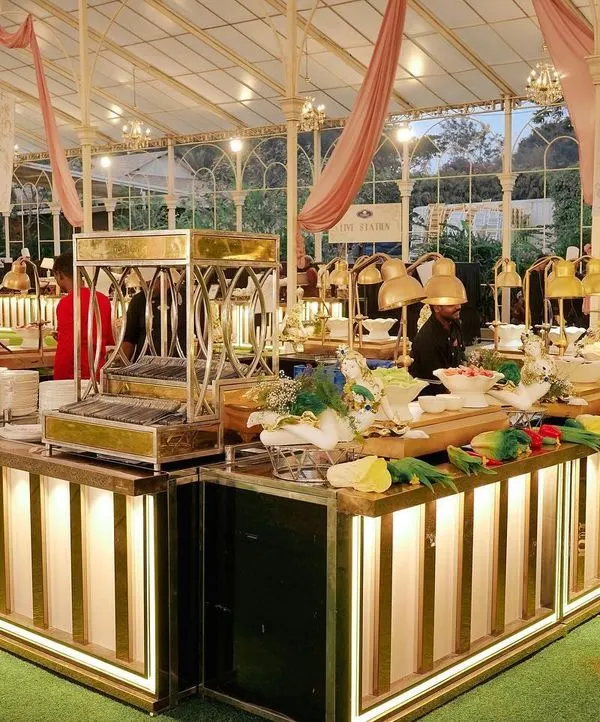 A view of our illuminated food stations at a premium wedding held in a glasshouse. The setup includes a salad bar and plate station, all elegantly designed to match the sophisticated ambiance of the event.
