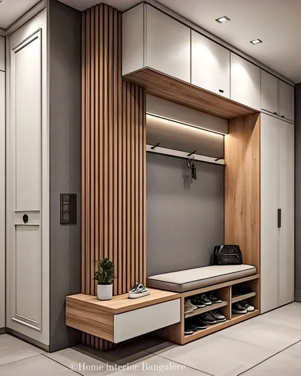 This complete entryway solution features floor-to-ceiling cabinetry for maximum storage. A central niche provides seating and coat hooks, with wood-fluted paneling and soft lighting adding a touch of warmth and modern design.