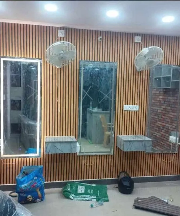 This is an in-progress look at a salon makeover in Bangalore. I used vertical wooden louver panels to create a warm, modern, and uniform look across the styling stations, providing a professional backdrop that enhances the client experience.