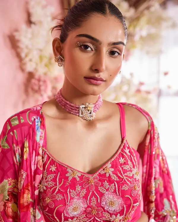 A close-up of a glamorous yet soft makeup look, perfect for a reception or engagement. The focus is on glowing skin, subtly defined eyes with a hint of sparkle, and a natural lip color that enhances the model's features.