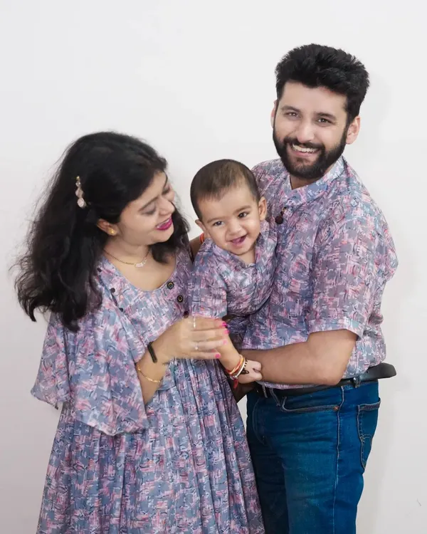 A happy family in coordinated outfits for their baby's first birthday shoot. This kind of pre-shoot planning results in beautiful, timeless portraits.
