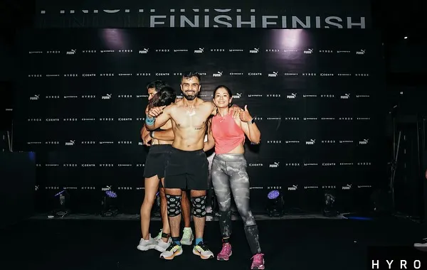 The finish line of a Hyrox race, completely spent but supported by my team. This is the culmination of months of dedicated training, a moment that shows the power of endurance and community.