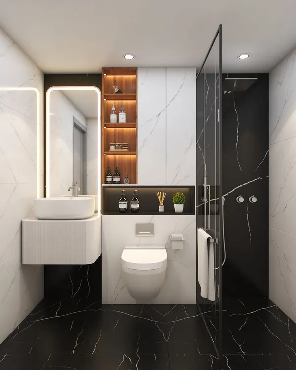 A classic and bold bathroom design. The contrast of black and white marble tiles creates a dramatic effect. The floating vanity and backlit mirror are modern touches that also save space.