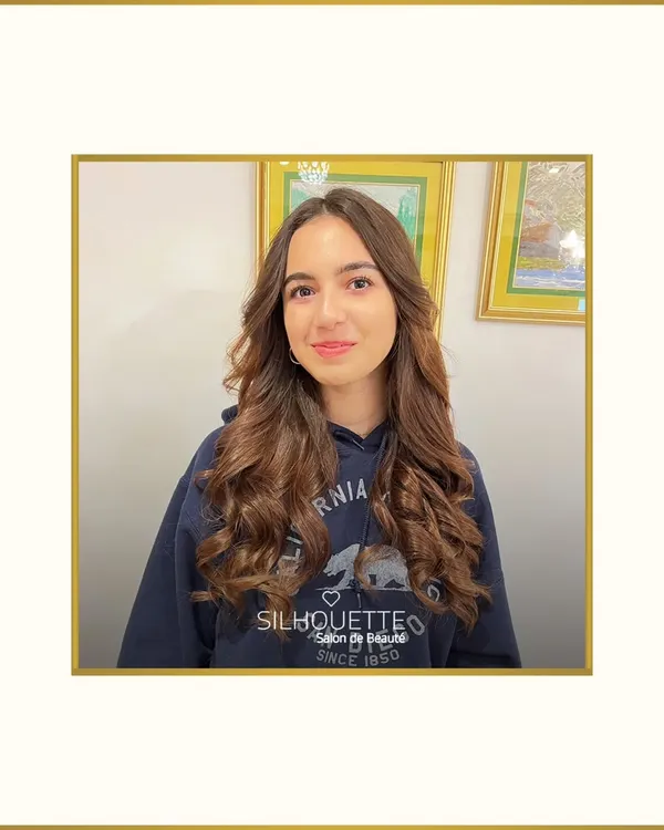 This look combines a soft, natural makeup application with beautifully styled bouncy curls. The makeup enhances her youthful glow with a hint of colour on the cheeks and lips, creating a fresh and radiant appearance.