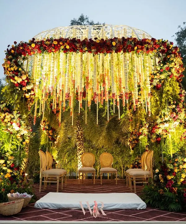 We designed this magnificent Vedi to honor timeless Indian heritage. The dome-shaped mandap, covered in a curtain of hanging white and red florals, created a sacred and breathtaking space for the couple to exchange their vows.