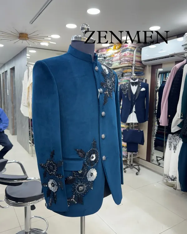 A glimpse of my teal velvet Jodhpuri suit on display in the studio. You can see the racks of fabrics and other designs in the background, showing the variety I offer.