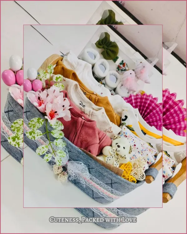 A beautifully arranged keepsake basket overflowing with soft, premium baby clothing, booties, and a cuddly teddy bear. This hamper is curated to be a perfect welcome gift, combining essential items with charming details.