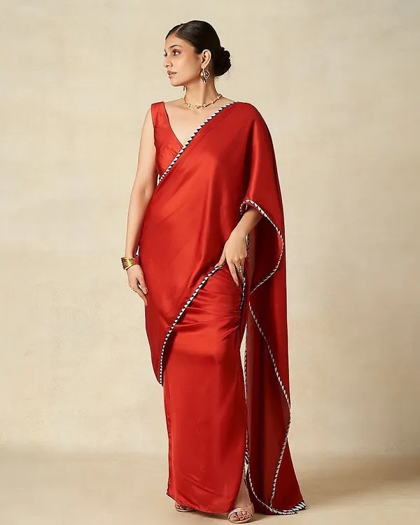 A sophisticated look for the Gulabo by Abu Sandeep campaign. The makeup is classic and elegant, with a clean low bun and a neutral palette to complement the vibrant red saree.