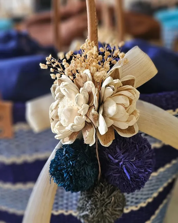A close-up look at the details on my eco-friendly raffia baskets. I use wooden flowers, colorful pom-poms, and dried botanicals to add a touch of charm and personality to each one.