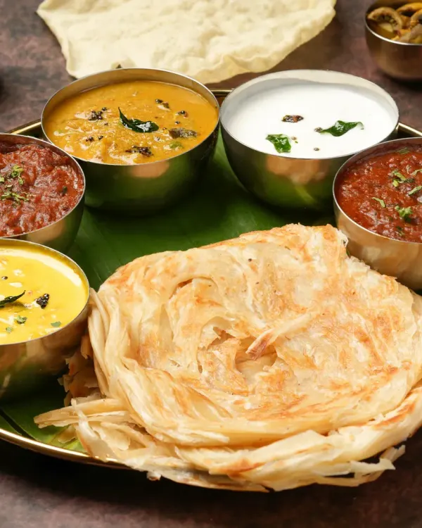 A South Indian thali is a feast for the eyes. We arranged each bowl and the flaky parotta to create a balanced and inviting composition, perfect for a feature spot on a restaurant's menu.