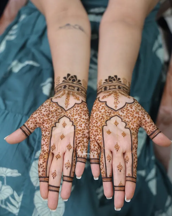 A perfect example of minimal bridal henna. This design uses negative space beautifully, with delicate leaf patterns and simple finger details for a very elegant look.