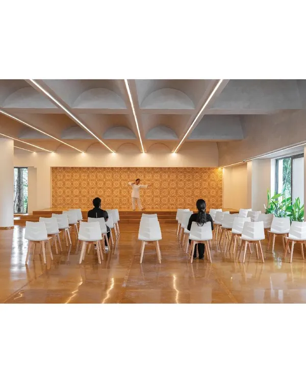 The multi-purpose hall at the Meraki Clubhouse, designed for community events and performances. We used a vaulted ceiling with integrated lighting and a patterned tile backdrop to create a space that is both elegant and functional, with excellent acoustics.