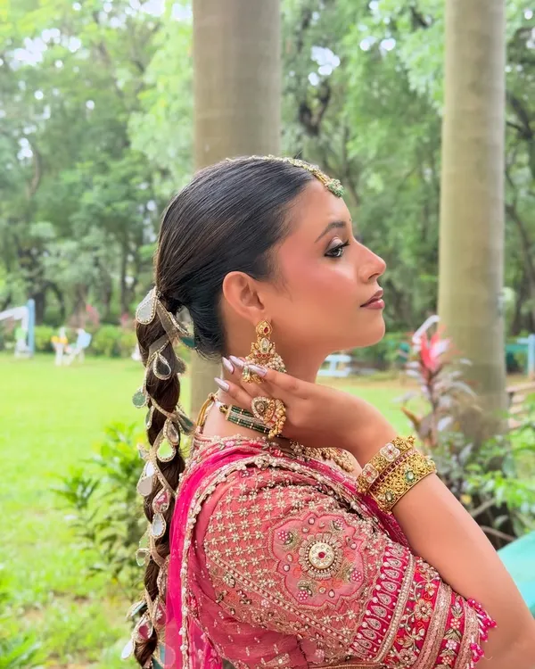 A side profile of a modern bridal look with a unique mirror-work braid.