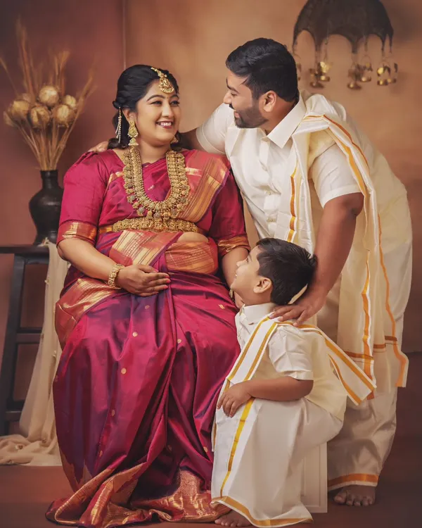 A beautiful family portrait celebrating their next chapter. The mother-to-be looks radiant in her silk saree, and the way her husband and son look at her is full of love and excitement.
