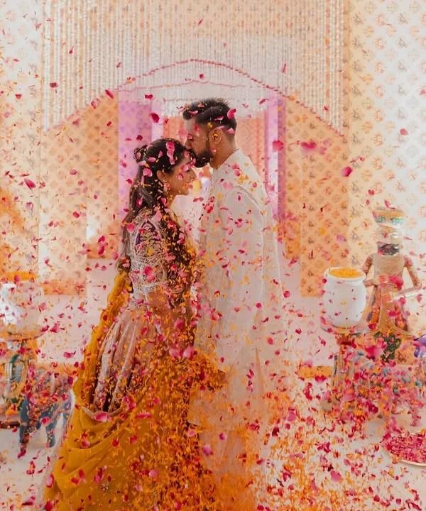 A magical moment from a Garba night, where the couple is showered in a rain of colorful petals. The decor, featuring traditional motifs and floral arrangements, created the perfect backdrop for this joyous celebration.